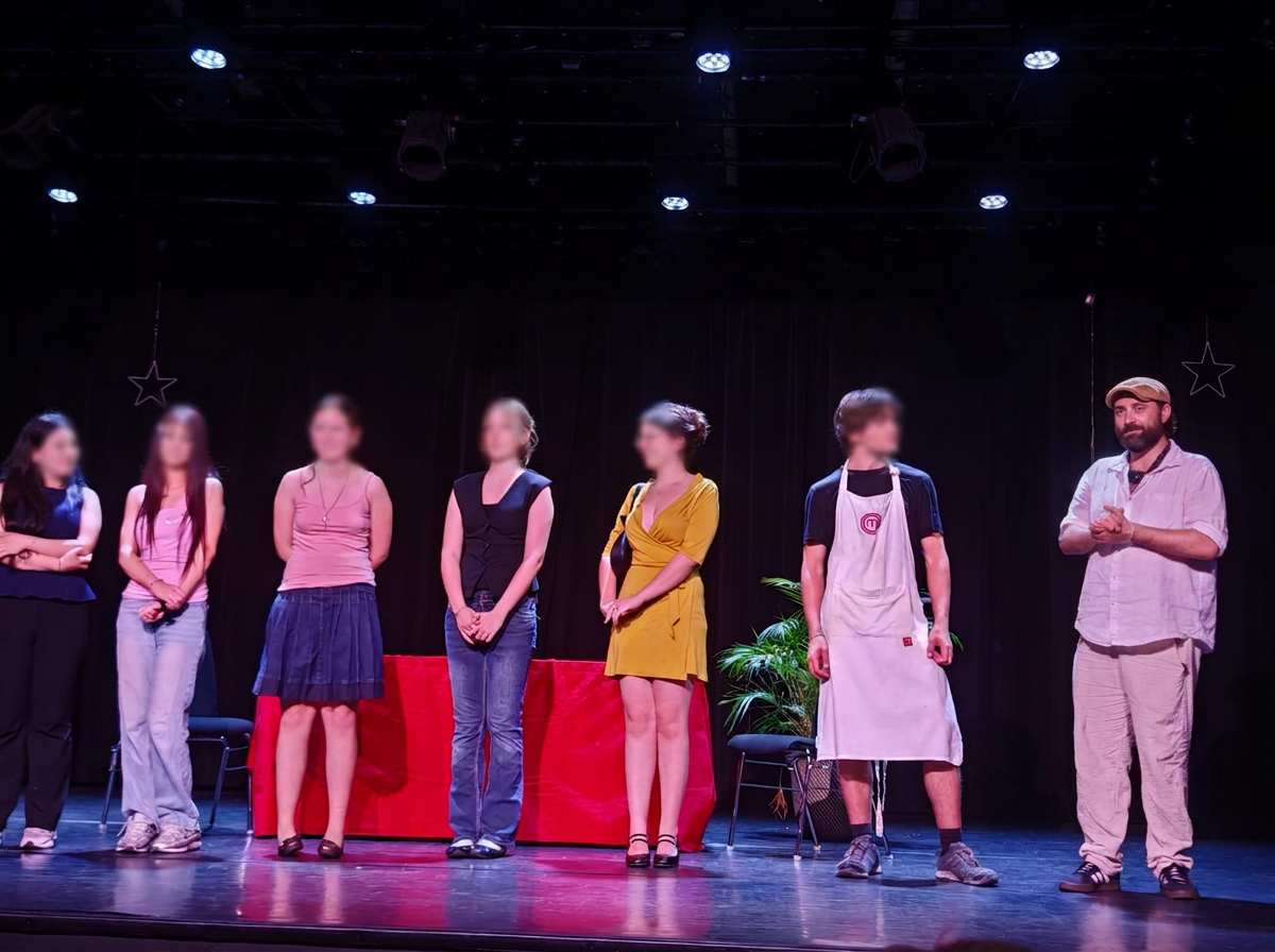 La troupe aux visages légèrement floutés saluant le public en fin de représentation